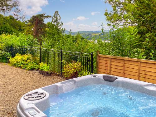 a hot tub in a yard with a fence at High Biggin in Windermere