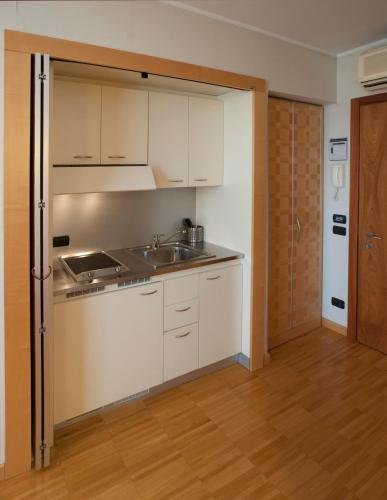 a kitchen with white cabinets and a sink at AlbaResidence Masera26 in Alba