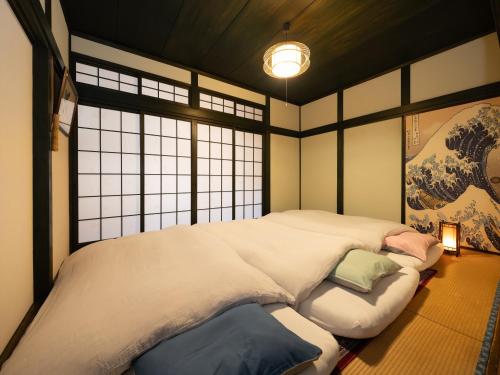 ein Schlafzimmer mit einem großen Bett und einem Fenster in der Unterkunft いけだ屋 in Kōzai