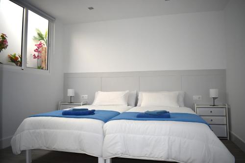 a bedroom with a large white bed with blue sheets at Apartamento Casa Leo in Playa Blanca