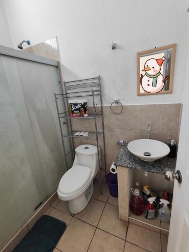 a bathroom with a toilet and a sink at La casa de Alex in San Juan Opico