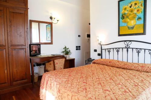 a bedroom with a bed and a desk and a mirror at Colleverde Country House & SPA Urbino in Urbino