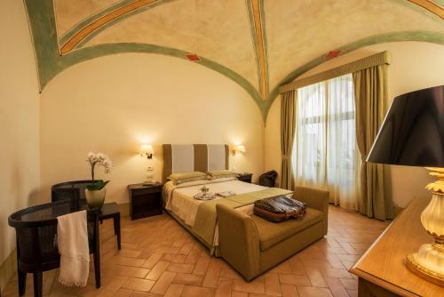a bedroom with a bed and a couch and a tv at San Biagio Relais in Orbetello