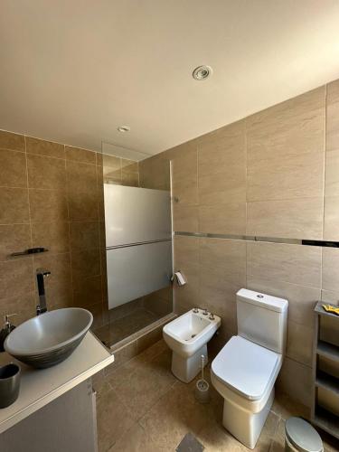 a bathroom with a white toilet and a sink at Alojamiento La Delfina in Chacras de Coria