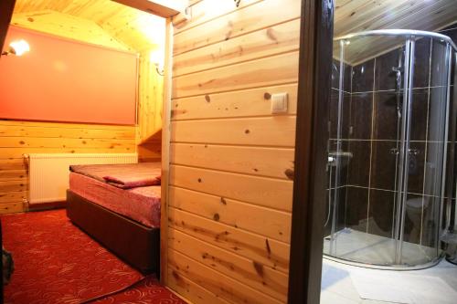a small room with a shower and a bedroom at Yedigoller Hotel & Restaurant in Uzungöl