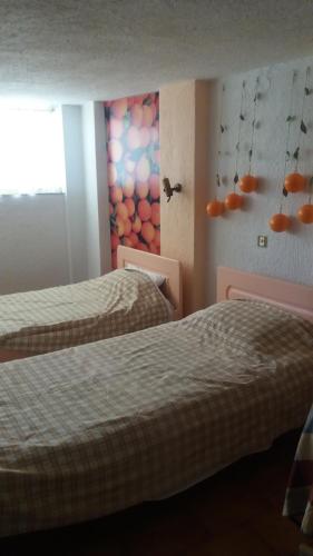 a room with two beds and a painting on the wall at Eleni Studios in Agios Nikolaos