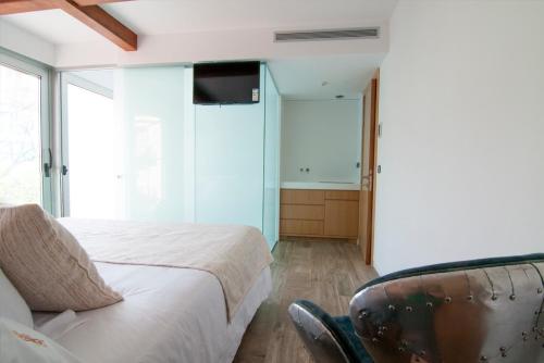 a bedroom with a bed and a tv and a chair at Cal Tonarro in Organyà