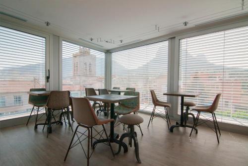 a room with tables and chairs and large windows at Cal Tonarro in Organyà