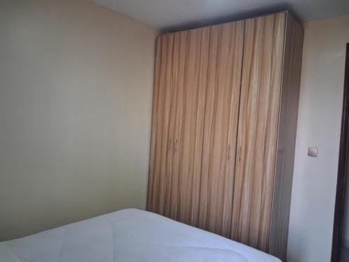 a bedroom with a bed and a wooden cabinet at Texas Apartments 1 Bedroom bnb Thika in Thika