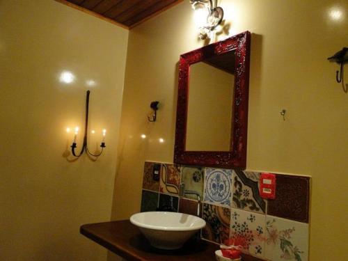 a bathroom with a sink and a mirror on the wall at Pousada Romântica Serra da Mata in Penedo