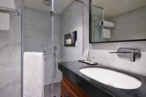 a bathroom with a sink and a shower at Varay Grande in Ujjain