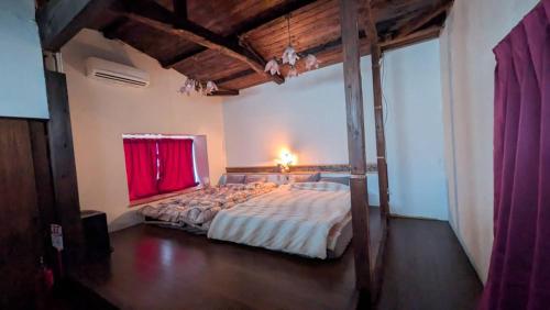 a bedroom with a large bed with a red window at CASA DE YOSHi 別館Annex, in Yamagata
