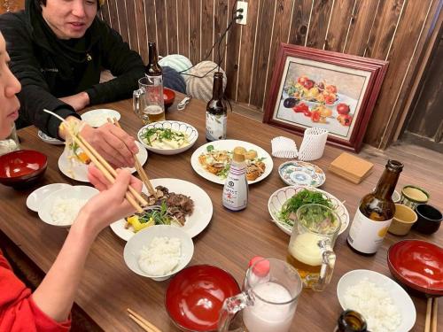 a group of people sitting at a table eating food at CASA DE YOSHi 別館Annex, in Yamagata