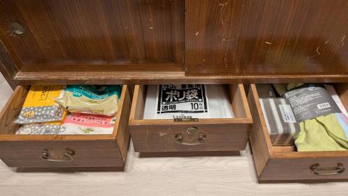 a wooden cabinet with three drawers with books in it at CASA DE YOSHi 別館Annex, in Yamagata