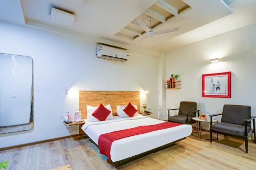 a bedroom with a large bed and two chairs at Hotel Wedlock Grand Suites Gurgaon in Gurgaon