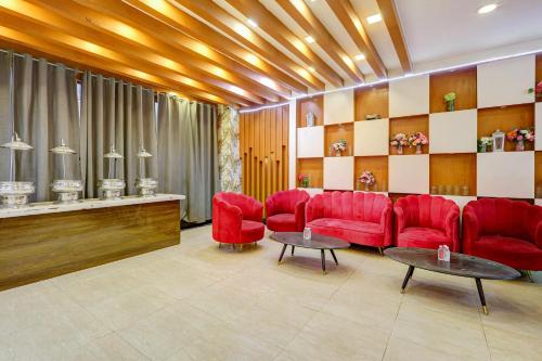 a waiting room with red chairs and a counter at Hotel Wedlock Grand Suites Gurgaon in Gurgaon