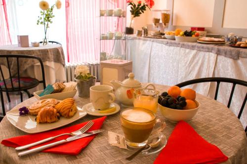 a table with a breakfast of coffee and croissants at Domus Hotel in Alessandria