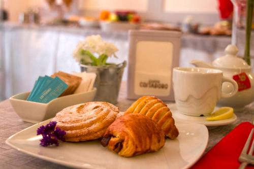 a plate with pastries and a cup of coffee on a table at Domus Hotel in Alessandria