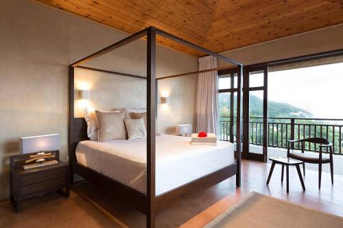een slaapkamer met een hemelbed en een balkon bij Villas Palm Royal in Port Glaud