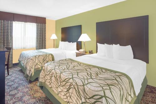 A bed or beds in a room at Baymont by Wyndham Holland