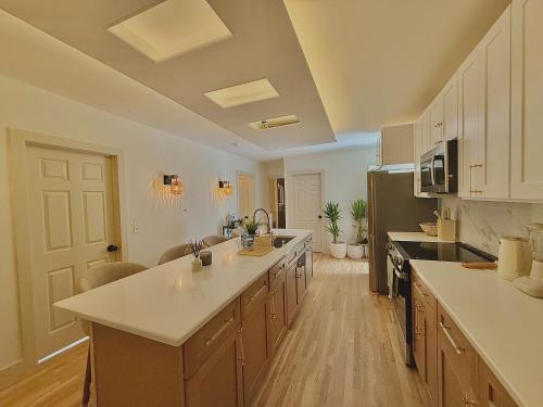 a large kitchen with white counter tops and cabinets at Spring Rooms by Yale & Downtown in New Haven