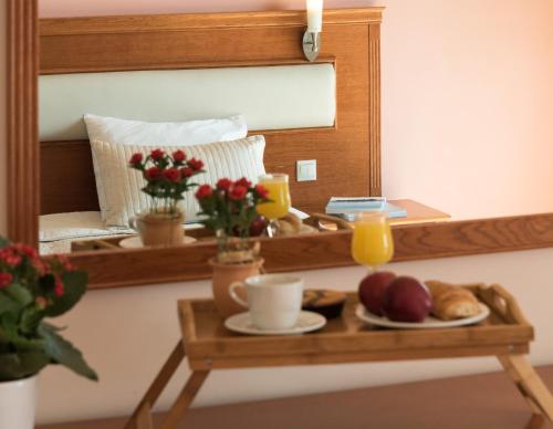 a table with a plate of food and a mirror at Acharnis Kavallari Hotel Suites in Athens