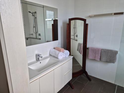 a white bathroom with a sink and a mirror at Whaler's Cove in Portland