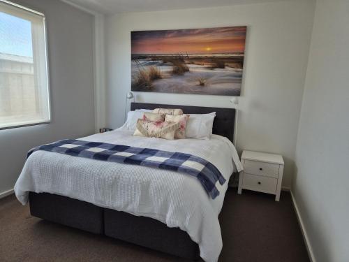 a bedroom with a bed with a painting on the wall at Whaler's Cove in Portland