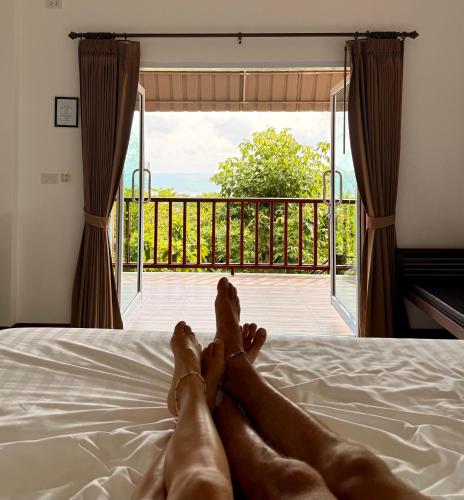 a pair of feet laying on a bed with a view at PawPaw Resort in Lamai