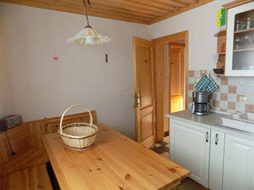 a kitchen with a wooden table with a basket on it at Apartment Zeleni dragulj Pohorje in Oplotnica