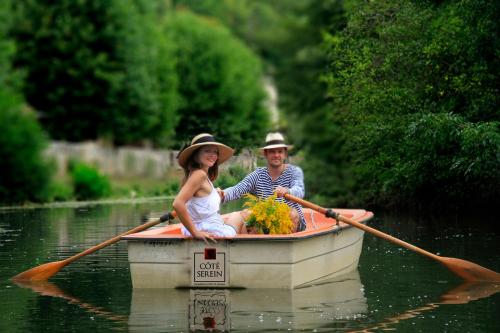 un hombre y una mujer en un barco en el agua en Côté-Serein - Domaine de Venoise, en Noyers-sur-Serein