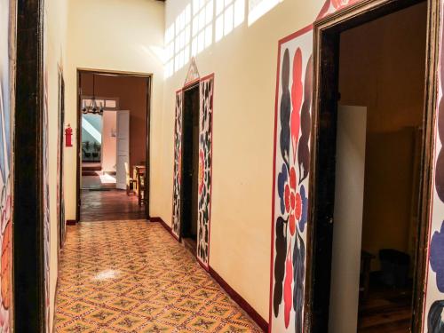 a hallway with paintings on the walls of a house at Wild Olive Guest House in Ica
