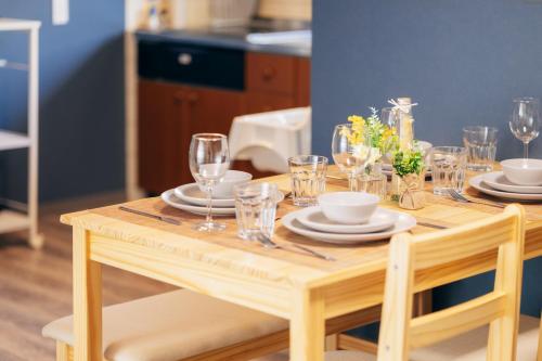 a wooden table with glasses and plates on it at 子連れ歓迎 平屋一棟貸し 3LDK 最大8名 プレイルーム付 法隆寺徒歩5分 HMV Horyuji in Ikaruga