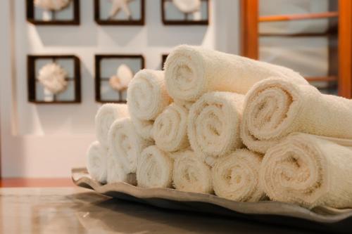 a pile of towels on a plate on a table at Victoria House Resort & Spa in San Pedro