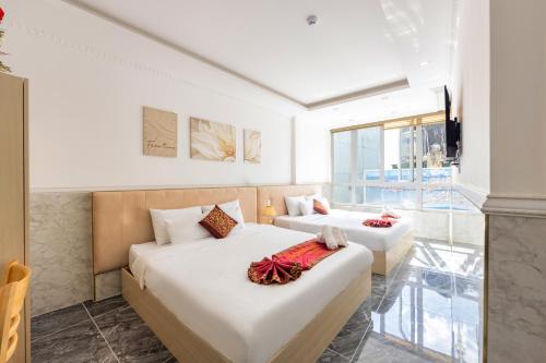 a bedroom with two beds and a balcony at Nghia Lan Hotel - Dalat Market in Da Lat