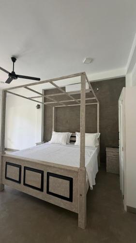 a bedroom with a canopy bed with white sheets at Villa Mario in Unawatuna