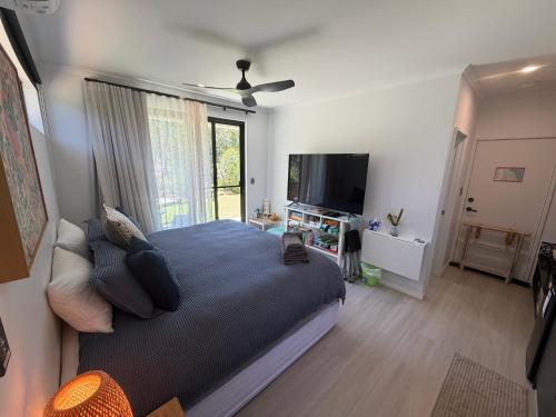 a bedroom with a large bed and a flat screen tv at Carnarvon Castle Eagle Bay in Dunsborough