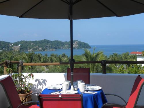 a table with a blue table cloth and an umbrella at Mar y Sueños in Sayulita