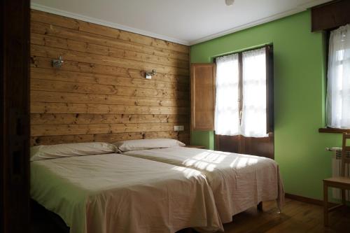 ein Schlafzimmer mit einem großen Bett mit grünen Wänden in der Unterkunft Casa de Aldea El Sol in Poo de Cabrales