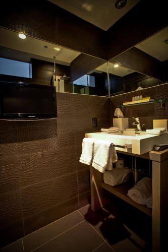 a bathroom with a sink and a mirror and towels at Prime Hotel Miami in Miami Beach