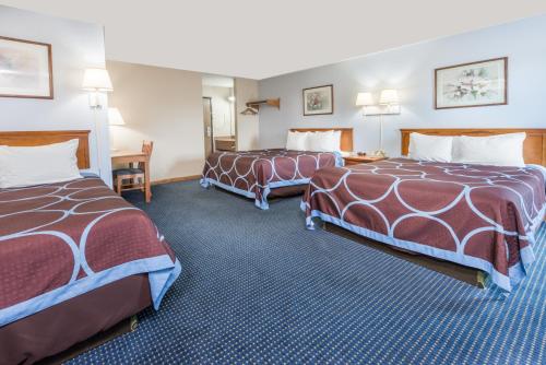 a hotel room with two beds and a desk at Super 8 by Wyndham O'Fallon MO/St. Louis Area in O'Fallon