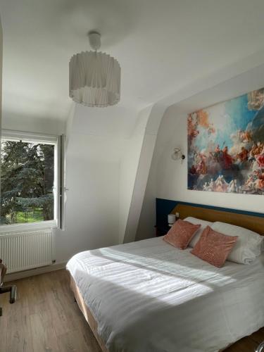 a bedroom with a bed and a painting on the wall at Aux Chambres des Dames in Chisseaux