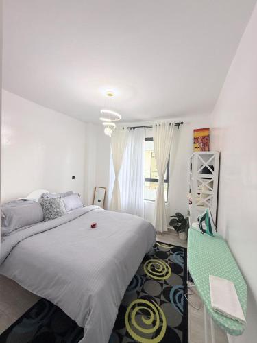 a bedroom with a large bed and a green chair at Kitusuru staycation in Wabuga