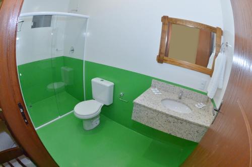 baño verde con aseo y lavamanos en Pousada Recanto das Cores, en Penha