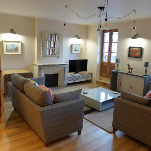 sala de estar con 2 sofás y TV en Poles Apart en Ax-les-Thermes