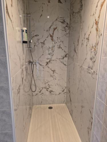 a shower with a wooden seat in a bathroom at Logis hôtel restaurant Le clos saint loup in Bram