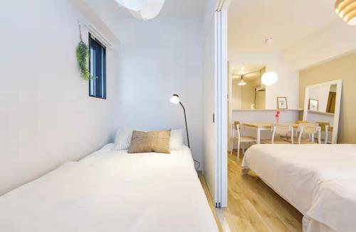 a bedroom with two beds and a dining room at TIC HOTEL NAGOYA Station in Nagoya