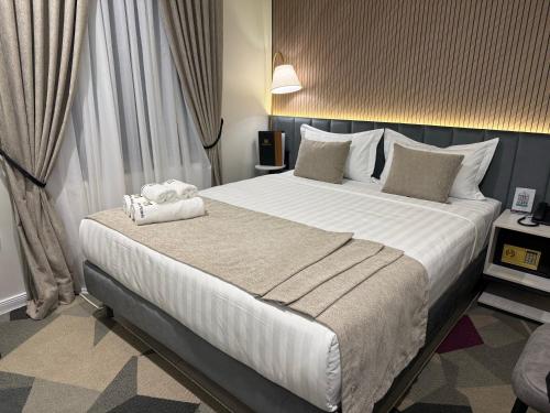 a bedroom with a large bed with white sheets and pillows at Marmaris Rakat Hotel in Yakkasaray
