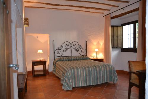 Cambil的住宿－Cortijo de Bornos，一间卧室配有一张床和两张台灯。
