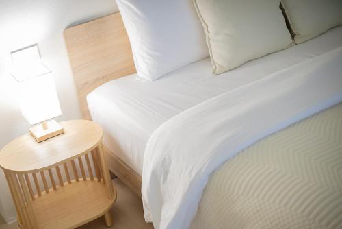 a bedroom with a bed and a table with a lamp at Quies Hotel in Krabi